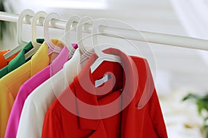 Multi-colored bright jackets on a hanger on a white background