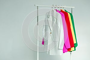 Multi-colored bright jackets on a hanger on a white background