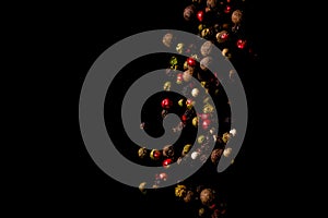 Multi-colored bright spices and peppers in flight on a black background