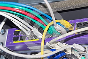 Multi-colored cables connected to equipment in telecommunication