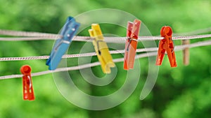 Multi-colored clothespins sway in the wind on the clothesline.