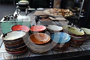 Multi-colored country-style faience plates for snacks, prepared for table setting