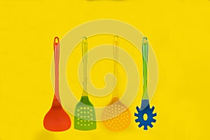 Multi-colored cutlery on a yellow background