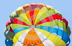 A multi-colored dome of a parachute in the sky as a background