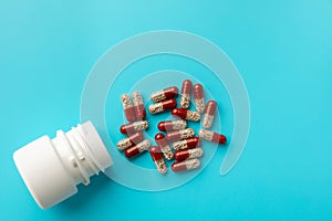 Multi-colored drugs and pills on a blue background. plastic white bottle. Blue background with copy space for text