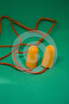 Multi-colored ear plugs on a green background. Close-up. Selective focus