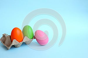 Multi-colored Easter eggs, hand-painted by children, lie on a blue background, top and side view