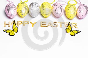 Multi-colored Easter eggs on a white background with a bunch of wooden letters Happy Easter. Happy Easter