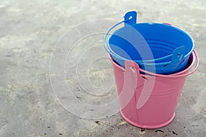 Multi-colored empty mini buckets on gray background. Aluminum bucket for flower garden for the manufacture of accessories for the