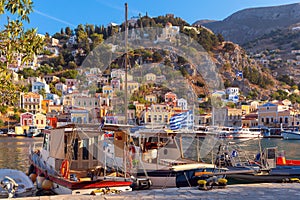 Multi-colored facades of houses in the village of Symi at sunset.