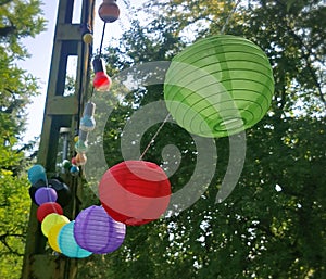 Multi-colored festive balls and light bulbs hung among the trees