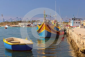 Multi-colored fishing boats luzzi with eyes in the harbor of the village Marsaxlokk on the island Malta.