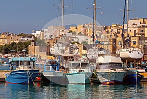 Multi-colored fishing boats luzzi with eyes in the harbor of the village Marsaxlokk on the island Malta.