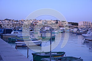 Multi-colored fishing boats rest in the sea bay.