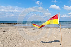 Multi-colored flag on a sandy beach. Denmark. North Sea. Seascape