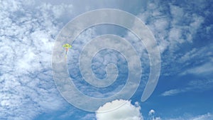 Multi-colored flying kite in a beautiful blue sky