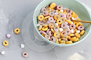 Multi colored fruit loops in a bowl with spoon