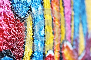 Multi colored graffito on a rough wall