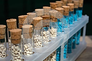 Multi-colored granules of micronutrient fertilizer in test tubes in a row