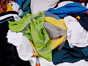 Multi-colored, green,blue, yellow and white, pile of clothes on sale in the apparel shop in the street market