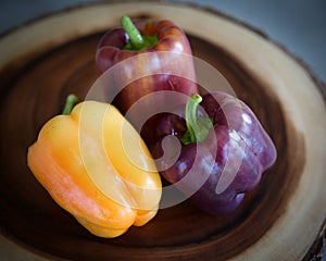 Multi Colored Heirloom Bell Peppers on a Wood Platter
