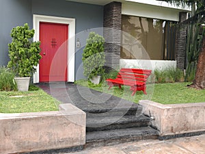 Multi colored house with a red door and bench in Lima