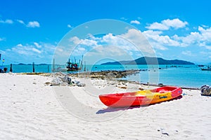 Multi-colored kayaks on a tropical sandy beach. Kayak rental. Tourist entertainment