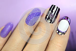 Multi-colored manicure with white and lilac varnish on various forms of nails