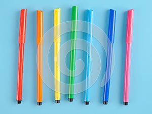 Multi-colored markers bright colorful on a blue background, children`s markers