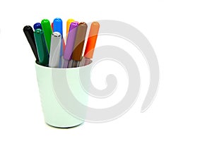 Multi colored markers in plastic cup isolated on a white background. Materials for children`s creativity