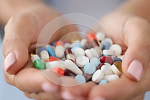 Multi-colored medical pills in female hands closeup