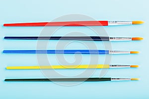 Multi-colored paint Brushes on a blue background