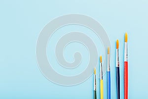 Multi-colored paint Brushes on a blue background