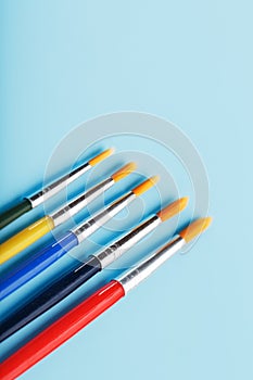 Multi-colored paint Brushes on a blue background