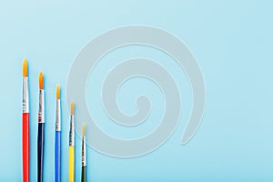 Multi-colored paint Brushes on a blue background