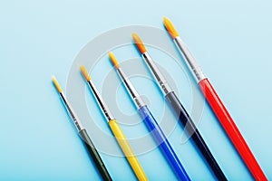 Multi-colored paint Brushes on a blue background