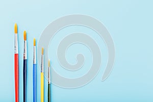 Multi-colored paint Brushes on a blue background