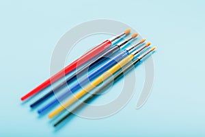 Multi-colored paint Brushes on a blue background