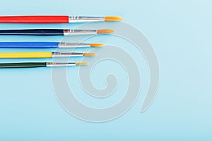 Multi-colored paint Brushes on a blue background