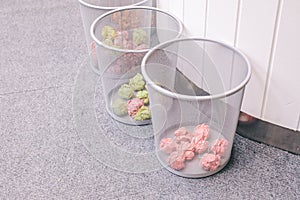 Multi colored paper balls office garbage near metal basket Small black trash bin