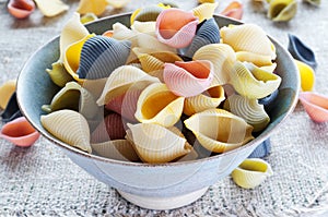 Multi colored pasta in bowl on coarse cloth