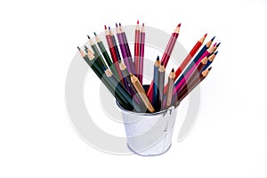 multi-colored pencils in a wine glass and a bucket. Selective blurred a group of coloring pencils in a wine glass on the isolated
