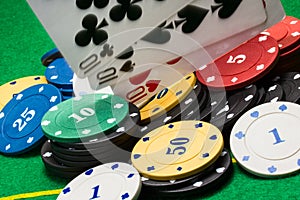 Multi colored pile of poker chips and falling cards