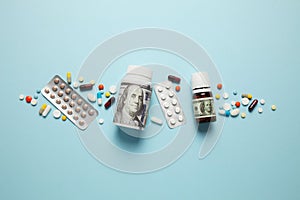 Multi-colored pills on blue background with one hundred dollar bill. Ð¡ost of health, medical insurance