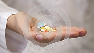 Multi-colored pills in hand. Close-up. Pain relievers. Antidepressants. Medicines for a healthy lifestyle. A doctor in a