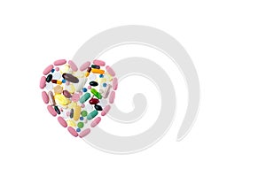 Multi-colored pills in the shape of heart on a white isolated background. Daily Vitamins dose. Heart shape made of
