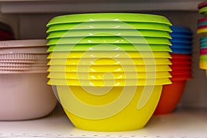 Multi-colored plastic bowls on the shelf in the store. Close-up