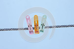 Multi colored plastic clothes clips on the rope.