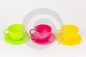 multi-colored plastic cups and plates on a white background kitchen set