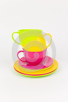 multi-colored plastic cups and plates on a white background kitchen set